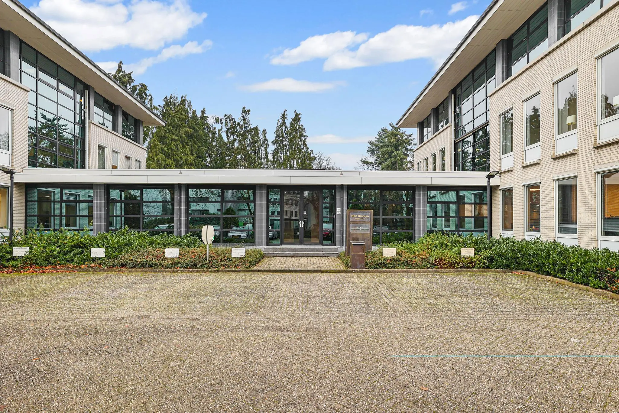 Vooraanzicht van een modern kantoorpand aan de Oude Utrechtseweg met parkeerplaats en groenvoorziening.